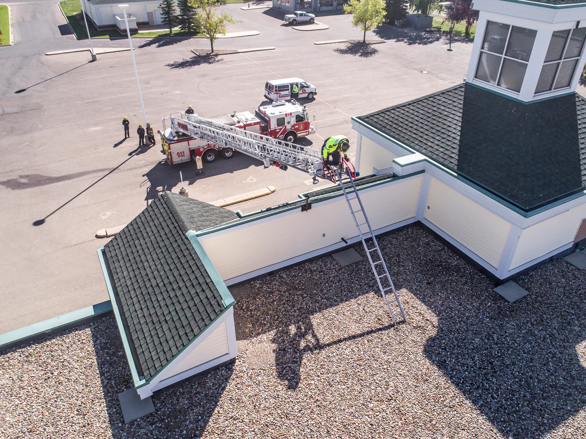 Lethbridge firefighters practise with an aerial apparatus beside a building.